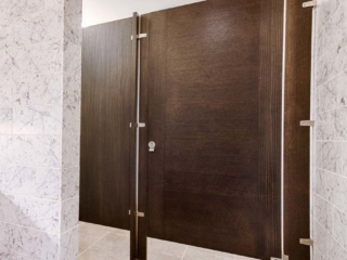 Elegant marble wall and countertop bathroom accentuating interesting contrasting grain, brown wood veneer door with inlay design.