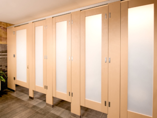 High privacy french vanilla plastic laminate bathroom partitions with luminous frosted acrylic door lite insert features zero sightline upgrade.