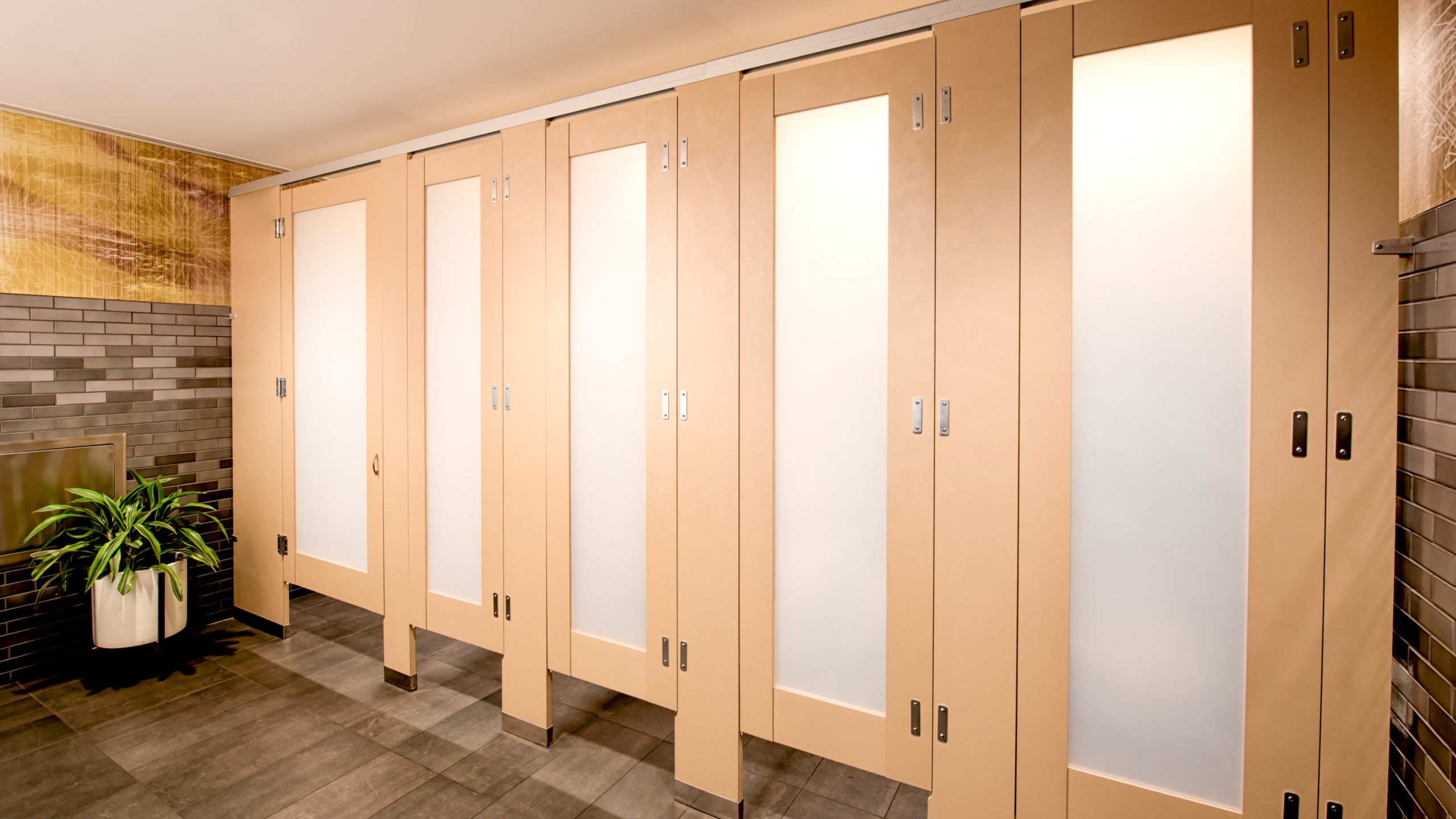 High privacy french vanilla plastic laminate bathroom partitions with luminous frosted acrylic door lite insert features zero sightline upgrade.