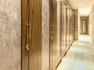 Expansive wildlife museum bathroom features eight, high privacy laminate doors with baby’s breath design on translucent acrylic door lite inserts.