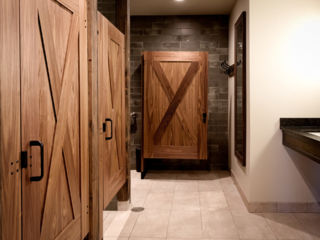 Luxury Montana lodge bathroom displaying three wood veneer captured panel doors with large X shape on both sides of doors in dark subway tiled room.