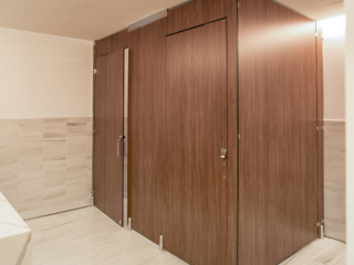 Executive office employee bathroom in compact laminate partitions with full height configuration showing transoms for added privacy.
