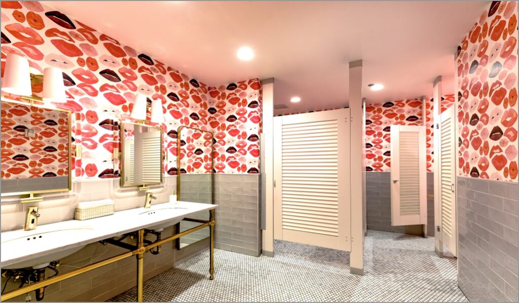 A bathroom with red and pink floral wallpaper, maintaining design intent even with the toilet partition. 