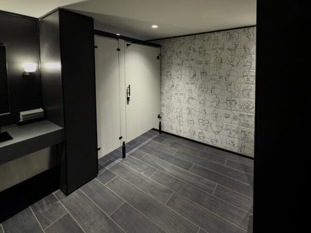 Headrail Braced toilet partitions in plastic laminate with zero-sightline for a commercial application. Image by Ironwood Manufacturing.