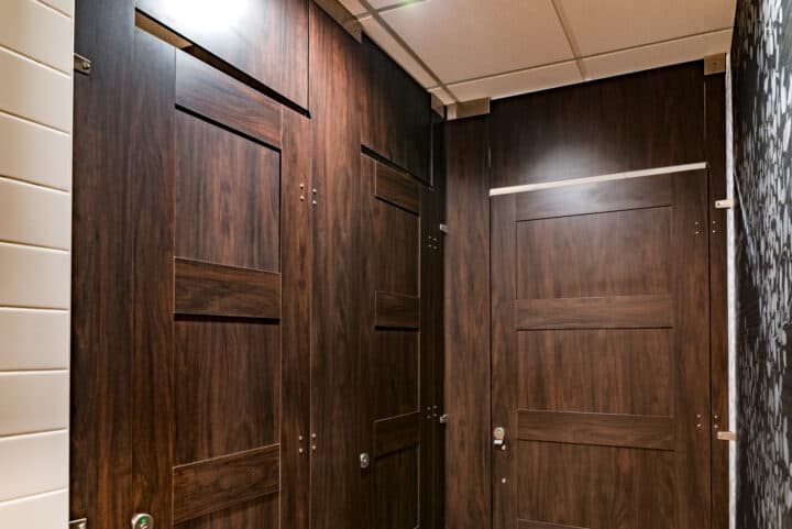 High privacy compact laminate restroom partitions with captured panel doors and transoms for added privacy and style.