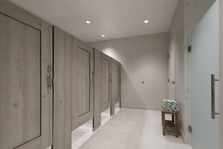 Country Club bathroom shows compact laminate dressing compartments with light tan, wood grain captured panel doors opposite frosted green shower door.