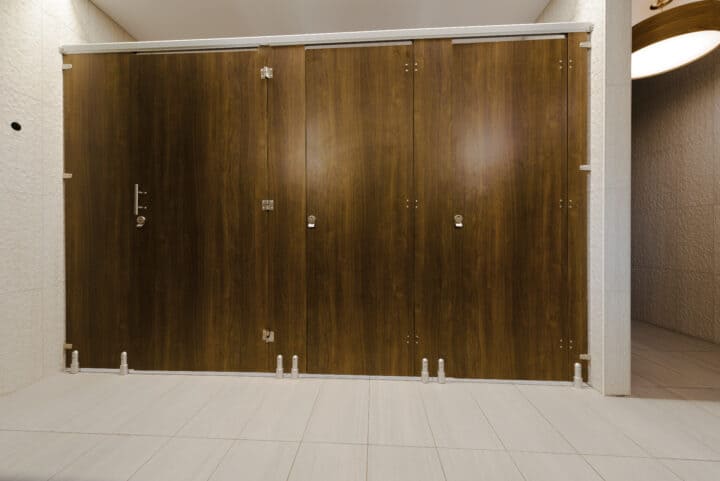 Modern high privacy partitions made of compact laminate in a European mount design, with a woodgrain finish.