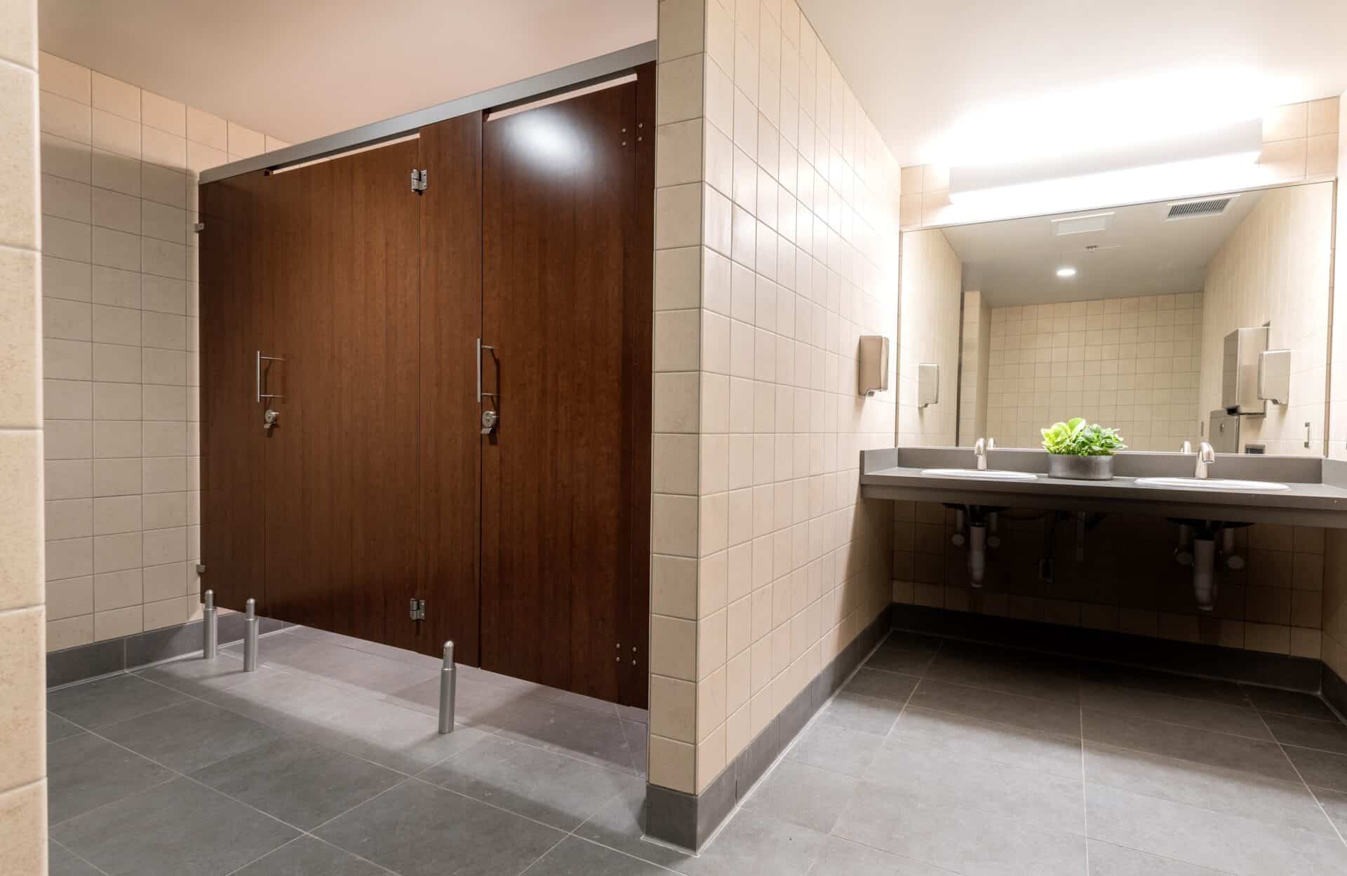 Public restroom with European mounting (headrail and pedestals) and flat slap doors in plastic laminate.