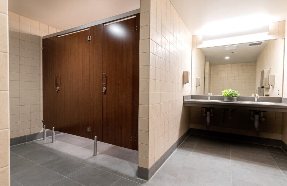 Public restroom with European mounting (headrail and pedestals) and flat slap doors in plastic laminate.