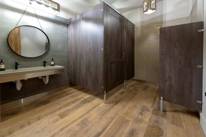 Commercial restroom with European mounting style (headrail and pedestals) and captured panel doors in plastic laminate.