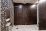 High privacy public restroom with woodgrain laminate, captured panels, floor to ceiling mounting with pedestals.