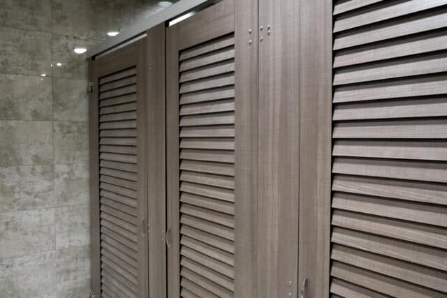 compact laminate louvered closet doors in a tiled room.