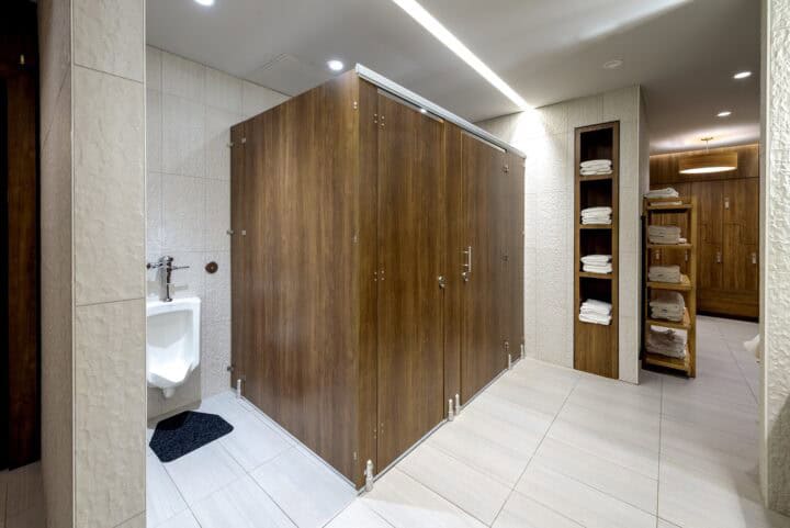Commercial restroom with European mounting (headrail and pedestals) and oversized doors and panels in compact laminate.