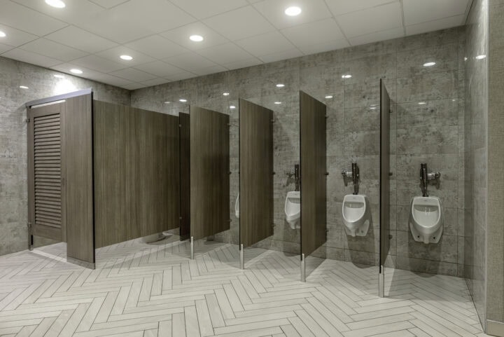 A row of urinals in a public bathroom, featuring urinal screens for added privacy and hygiene.