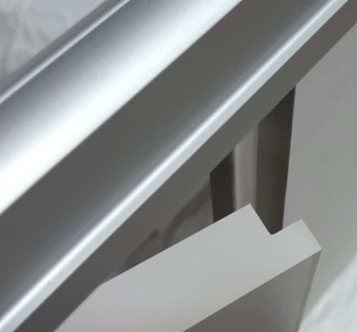 Close-up view of Ironwood Manufacturing’s Zero Sightline toilet partition hardware showing interlocking door and pilaster components with clean matte finishes